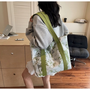 Lifestyle shot showing the large capacity tote bag with green bamboo prints and straps