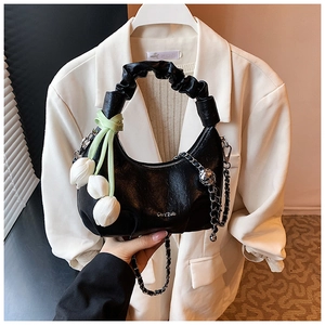 Detail of black cloud bag featuring leather texture, tulip charms and silver chain