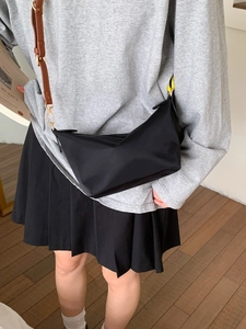 Sac bandoulière demi-lune en nylon noir avec sangle en cuir marron et métal doré