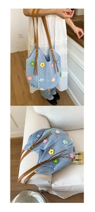Detail of light blue floral crochet tote bag with colorful hand-knit flowers and brown straps