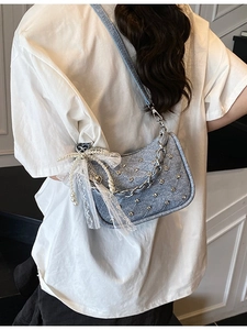Sac bandoulière en denim bleu clair avec clous argentés, chaîne et détail nœud perle