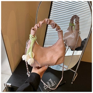 Pink crescent handbag detail with pleated handle, silver chain and tulip charm accent