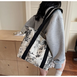 Detailed view of canvas tote bag featuring oriental ink bamboo print and black strap