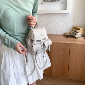 Mini textured leather backpack detail showing bucket shape and adjustable straps