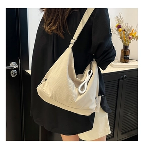 Vue latérale du sac polochon beige léger en nylon souple avec nœud décoratif chic