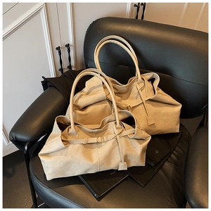 Detailed view of beige faux leather tote bags with soft pleated texture and slim handles