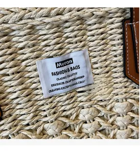 Dettaglio della trama in paglia intrecciata beige con etichetta Muran e bordo in pelle marrone