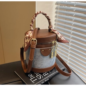 Detail of a denim and brown leather bucket bag with houndstooth silk scarf handle wrap