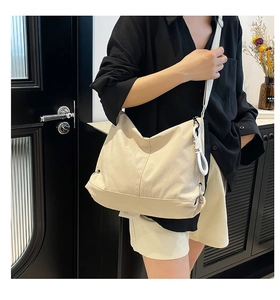 Vue latérale du sac à main beige en toile montrant la taille sur un mannequin