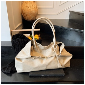 Close-up of a large cream tote bag on black steps with minimalist lifestyle decor