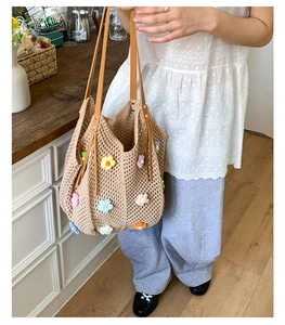 Detail of hand-crocheted floral tote bag with camel leather straps and metal rivets