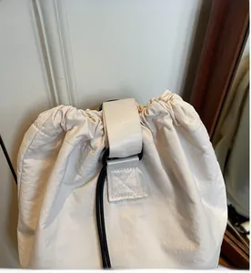 Detail view of the drawstring closure and reinforced handle on the off-white nylon bag