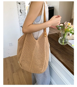 Detail of woven flower tote bag with leather shoulder strap and metallic rivet hardware