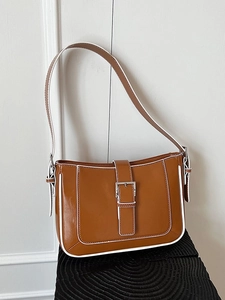Minimalist brown crescent shoulder bag with white contrast piping and silver buckle