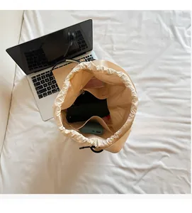 Top view showing the spacious interior of the beige drawstring bucket bag with pockets