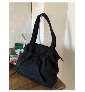 Detail einer schwarzen Nylon-Tragetasche mit Kordelzugfalten und stabilen Schultergurten