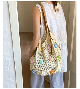 Detailed texture of crochet tote bag with colorful 3D flowers and leather handles