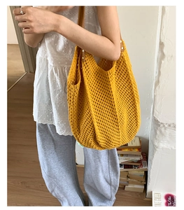 Detail of yellow hollow knit tote bag showing thick weave texture and reinforced rivets