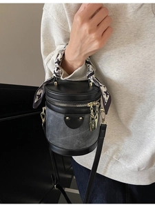 Chic grey canvas bucket bag with black leather trim and decorative houndstooth scarf handle