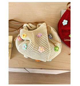 Top view of woven crochet bucket bags with colorful floral decors on wood surface