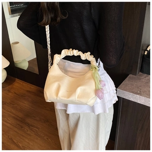 Detail of off-white ruched dumpling bag with tulip charm and silver chain strap