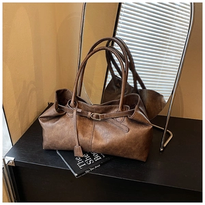 Detail of vintage brown tote bag with leather strap buckle and long handles in retro mood