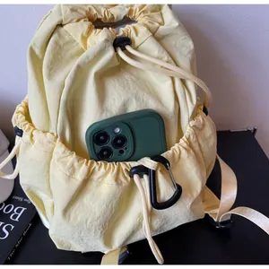 Close-up of drawstring side pocket on nylon backpack holding a green smartphone