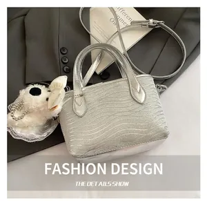 Detail of silver textured mini bag with glitter finish and plush puppy charm
