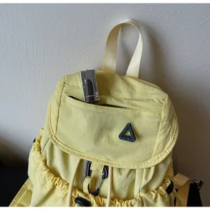 Detail of drawstring backpack with front zipper pocket and lipstick for size reference