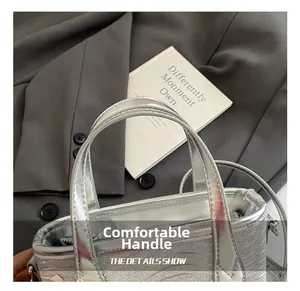Detail of silver tote bag featuring metallic wavy texture and comfortable top handles