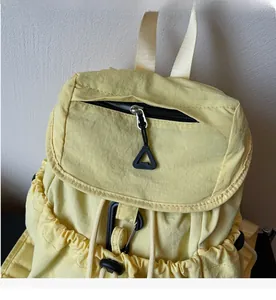 Close-up of smooth metal zippers and drawstring closure on a nylon backpack