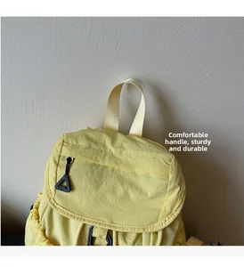 Detail view of reinforced yellow backpack handle and durable nylon fabric texture
