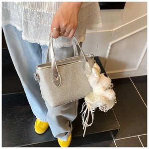 Detail of silver sequin handbag with cute white plush bunny charm accessory