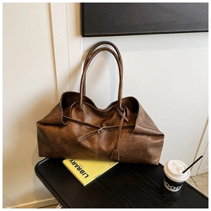 Detailed macro view of retro brown faux leather texture and metallic buckle on tote bag
