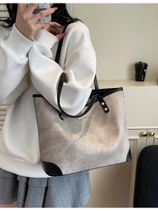 Large gray tote bag with black leather trim shown on a model for daily commute styling