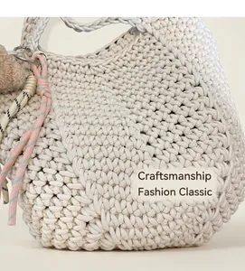 Close-up of beige hand-woven tote bag with cotton rope texture and metal ring details