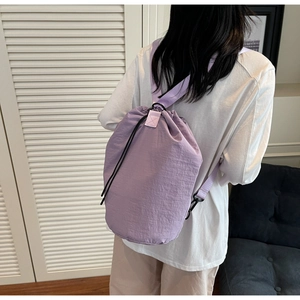 Rear view of a light purple drawstring bucket bag in a casual lifestyle setting
