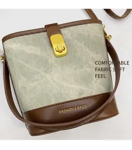 Dettaglio borsa retrò bicolore in pelle marrone e tessuto grigio con chiusura oro