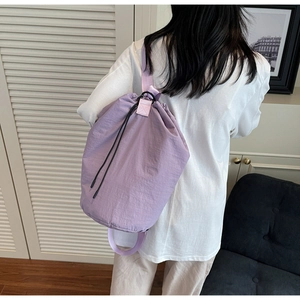 Detail view of the lavender drawstring bucket bag in waterproof nylon on a model