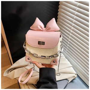 Straw mini crossbody bag with a large pink bow and silver chain strap detail