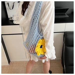 Close-up of light blue hollow woven bag with yellow sunflower accent and mesh texture