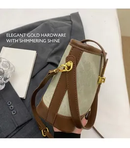 Dettaglio della borsa a secchiello retrò in tela beige con finiture in pelle marrone e oro