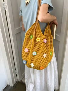 Yellow hand-woven crochet tote bag with colorful 3D floral accents and brown leather handles