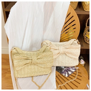 Detail von Stroh-Schleifentaschen in Khaki und Cremeweiß mit goldenen Kettenriemen