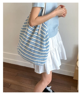 Close-up of blue and white striped crochet tote bag with hollow knit texture and shoulder strap