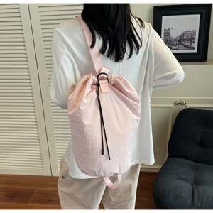 Close-up of light pink drawstring bucket bag with durable nylon fabric and black buckles