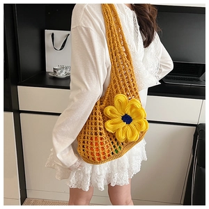 Detail of yellow handmade crochet tote bag featuring 3D flower and mesh design