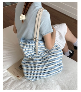 Close-up of blue and white striped crochet tote bag with adjustable leather straps