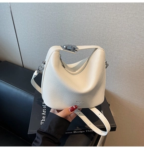 Detail shot of white lychee leather texture and elegant silver metal buckle on handbag