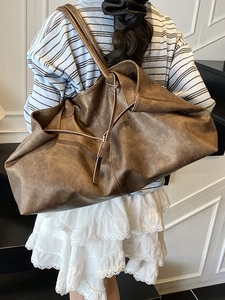 Retro brown oversized PU leather tote bag with vintage texture shown on shoulder